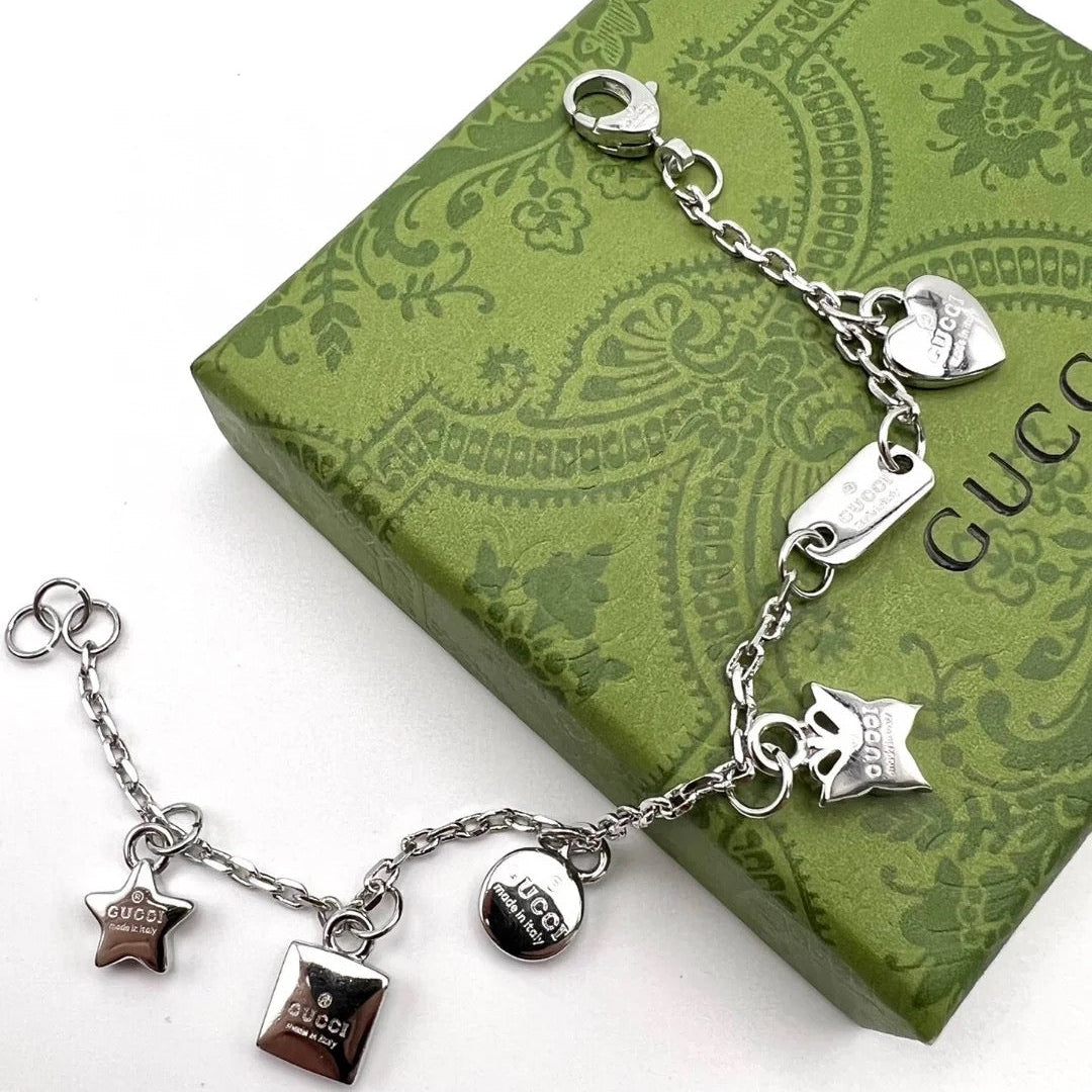 Silver bracelet with charms on a Gucci box