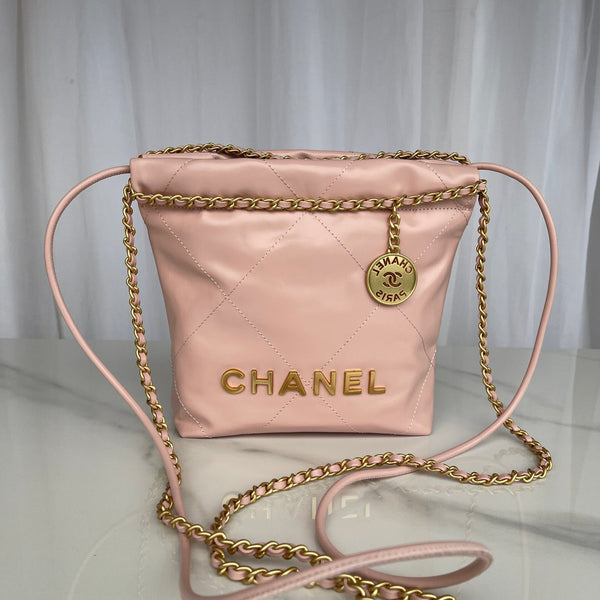 Pink Chanel handbag with gold chain strap on a white background
