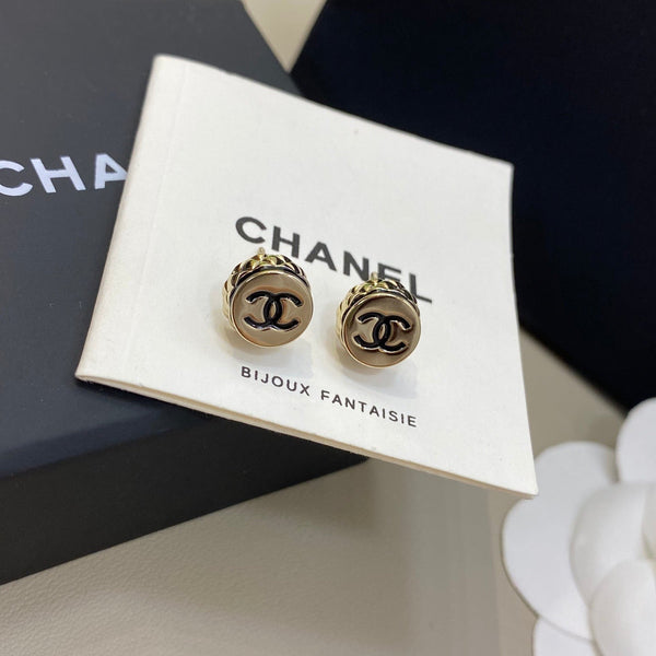 Chanel earrings on a branded card with a Chanel box in the background
