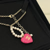 Necklace with pink heart pendant and pearl chain on a black background