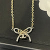 Gold and silver bow-shaped necklace on a black Chanel card
