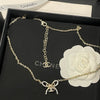Chanel necklace with bow charm on a black Chanel box with white rose
