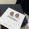 Chanel earrings on a branded display card with a black box in the background