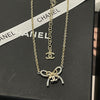 Gold necklace with bow pendant on a Chanel branded box