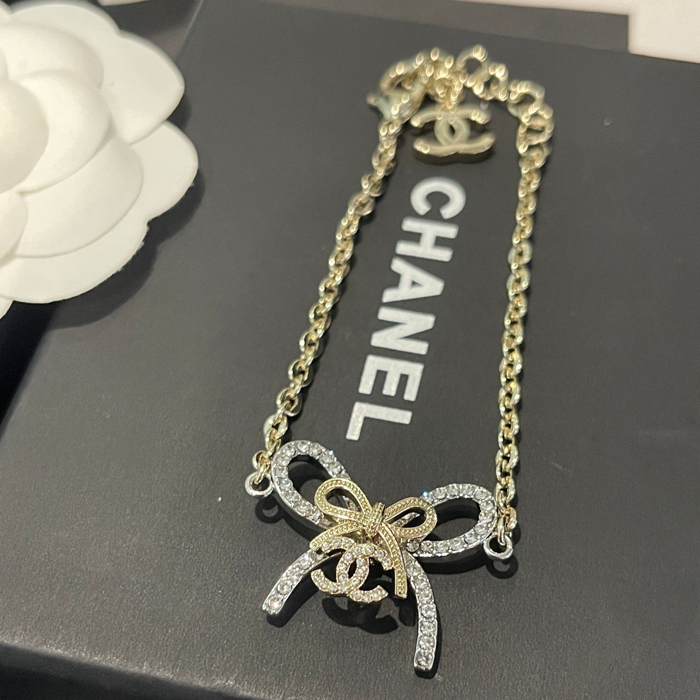 Butterfly-shaped necklace with Chanel logo on a black Chanel box