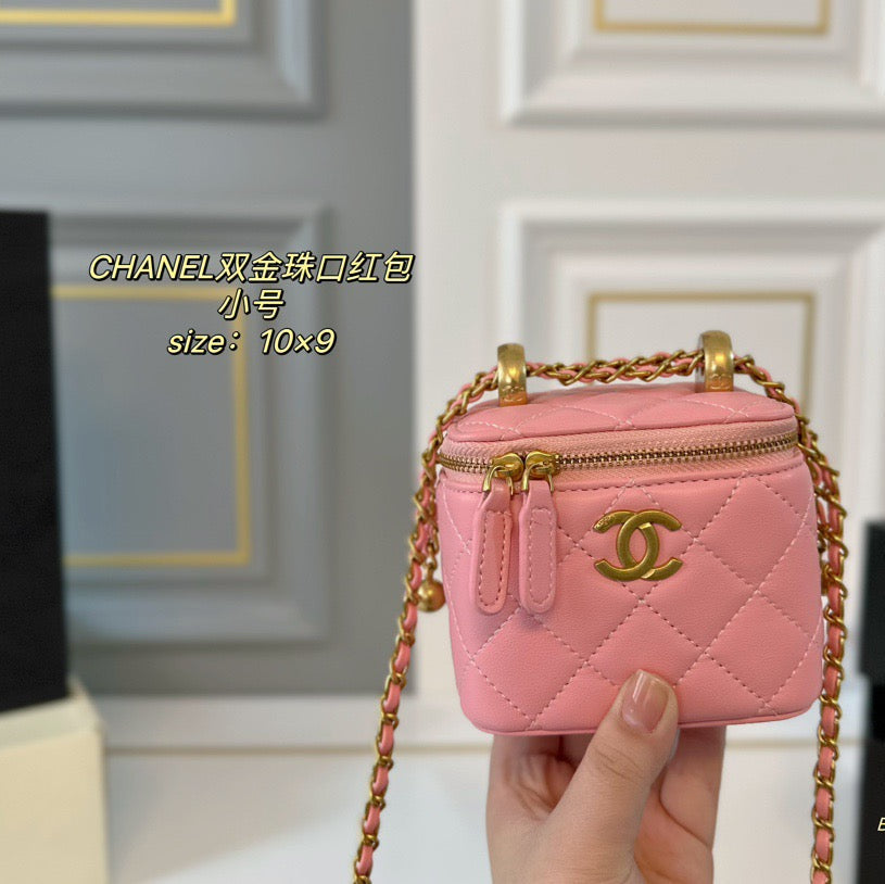 Pink Chanel handbag with gold chain held by a hand against a neutral background