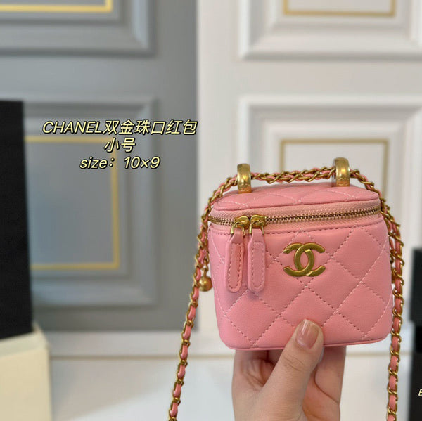 Pink Chanel handbag with gold chain held by a hand against a neutral background