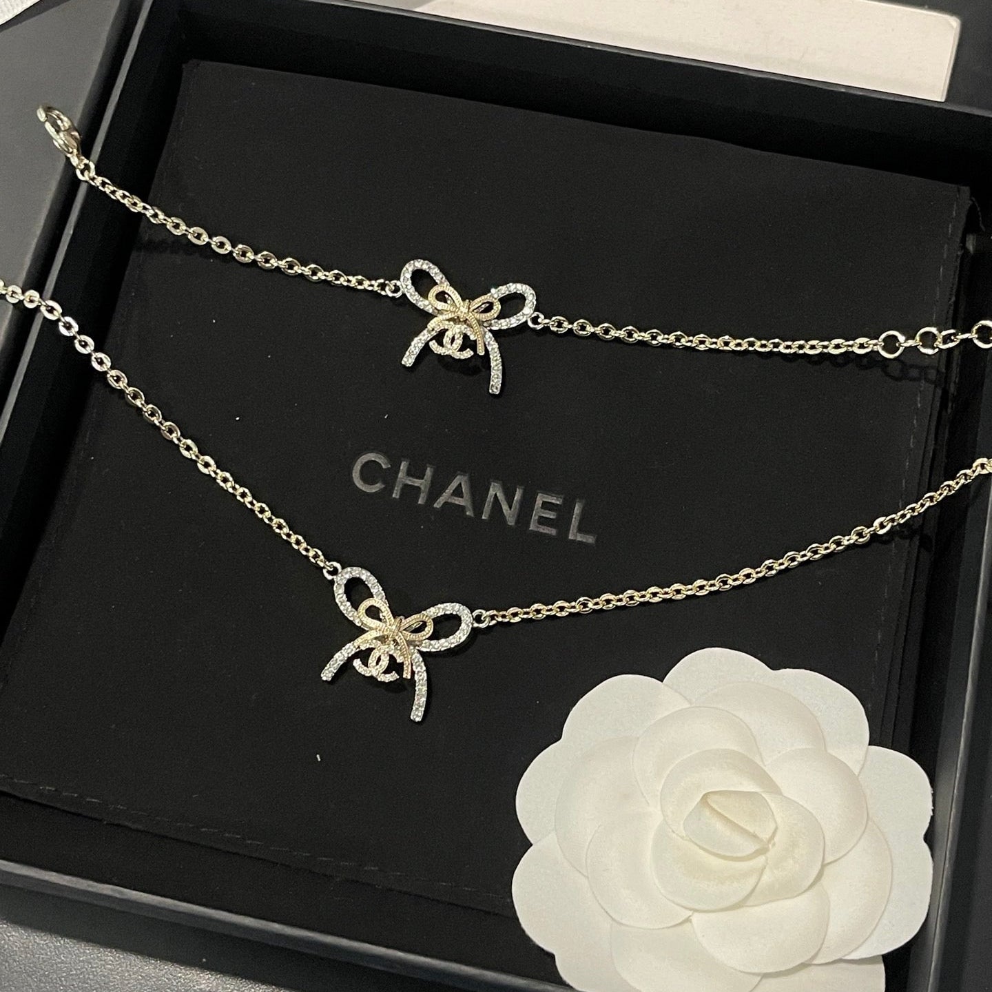 Chanel necklace with bow detail in a black box with Chanel branding