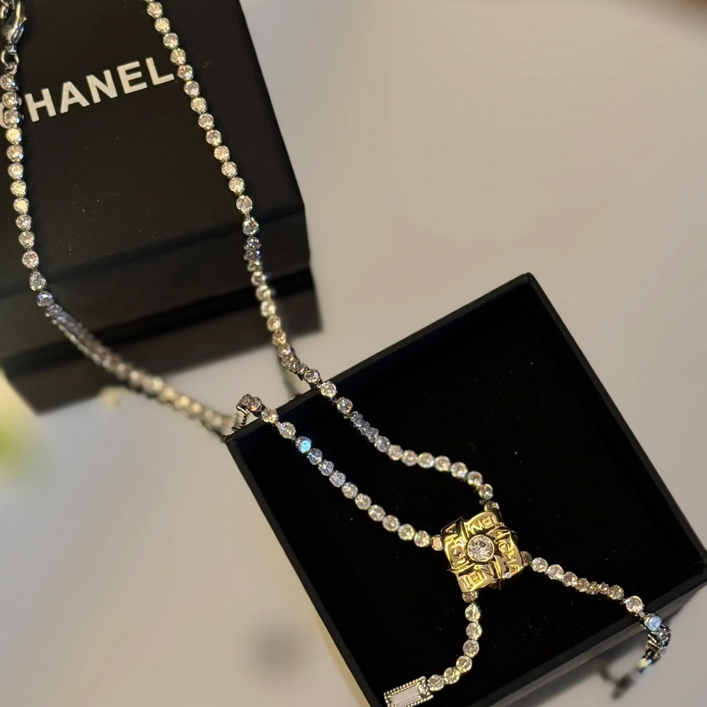 Chanel necklace on a black box with blurred background